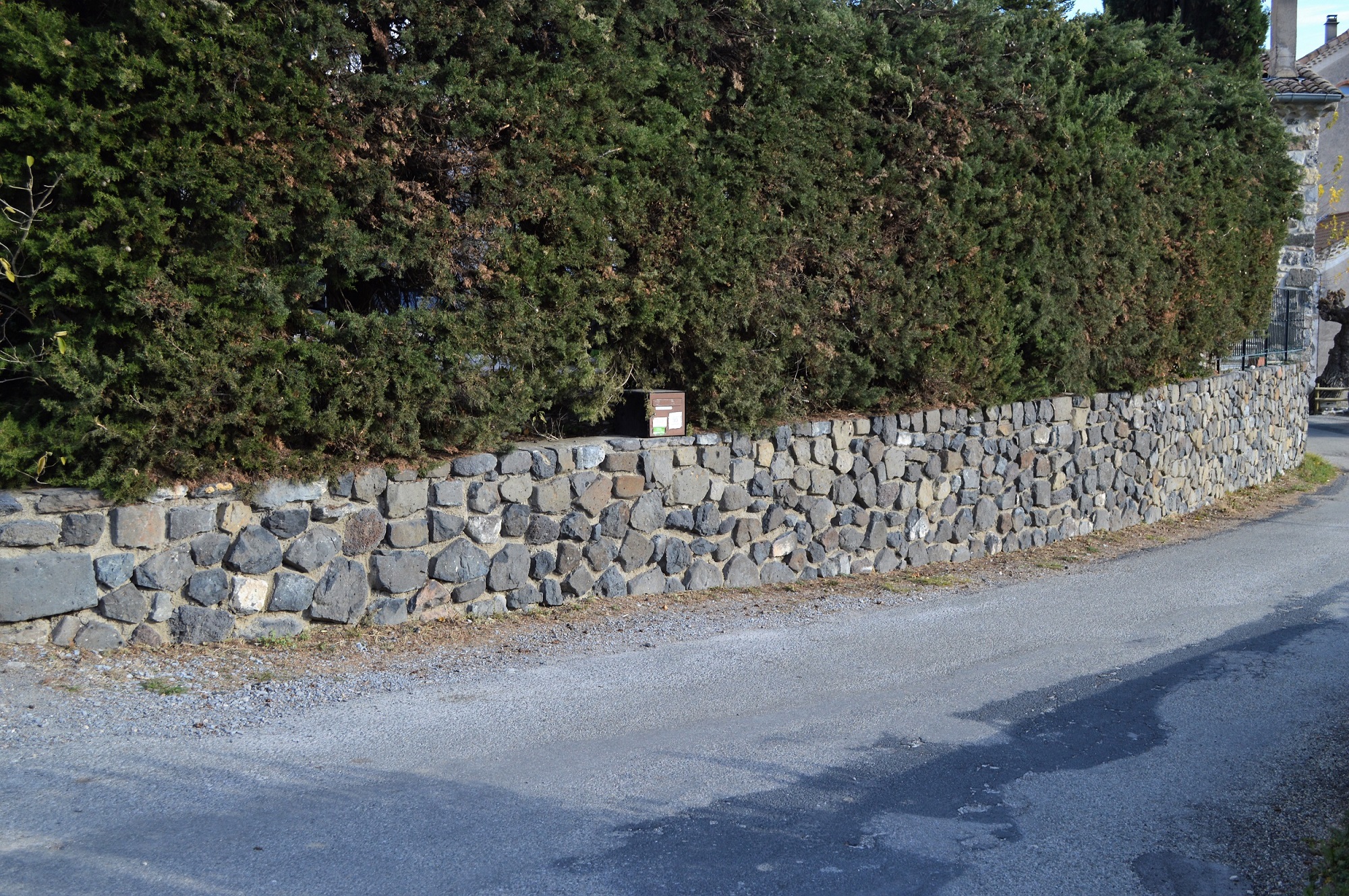 Parement en pierres de basalte devant un mur de soutènement en BA.
